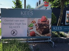 Buiten banner Kees, ter promotie van de High Tea